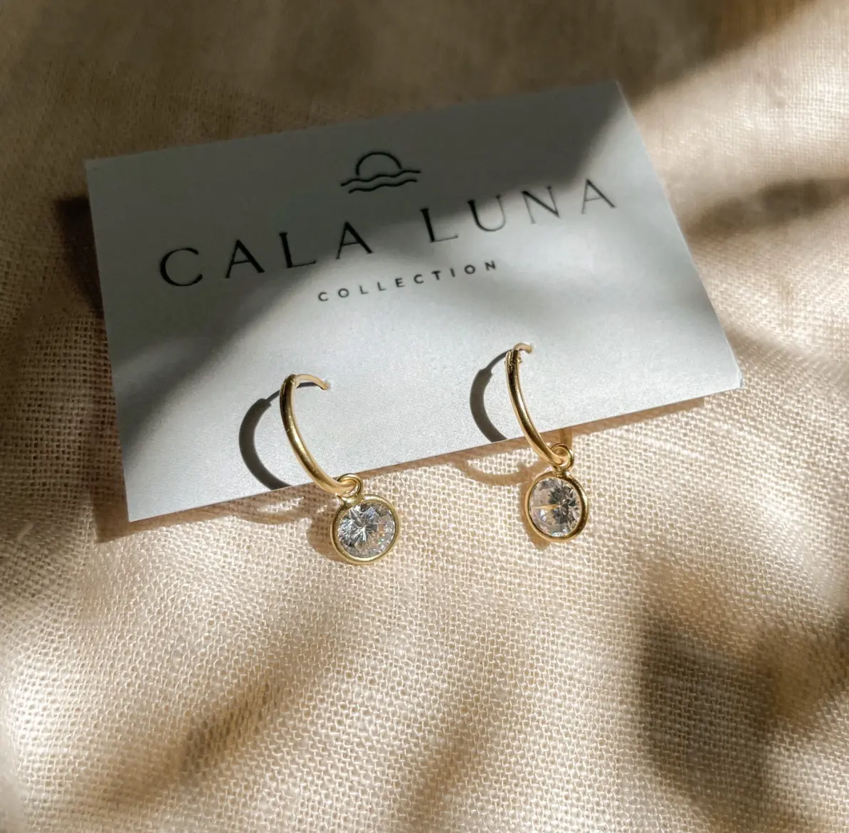 Delicate pearl huggie earrings in sterling silver